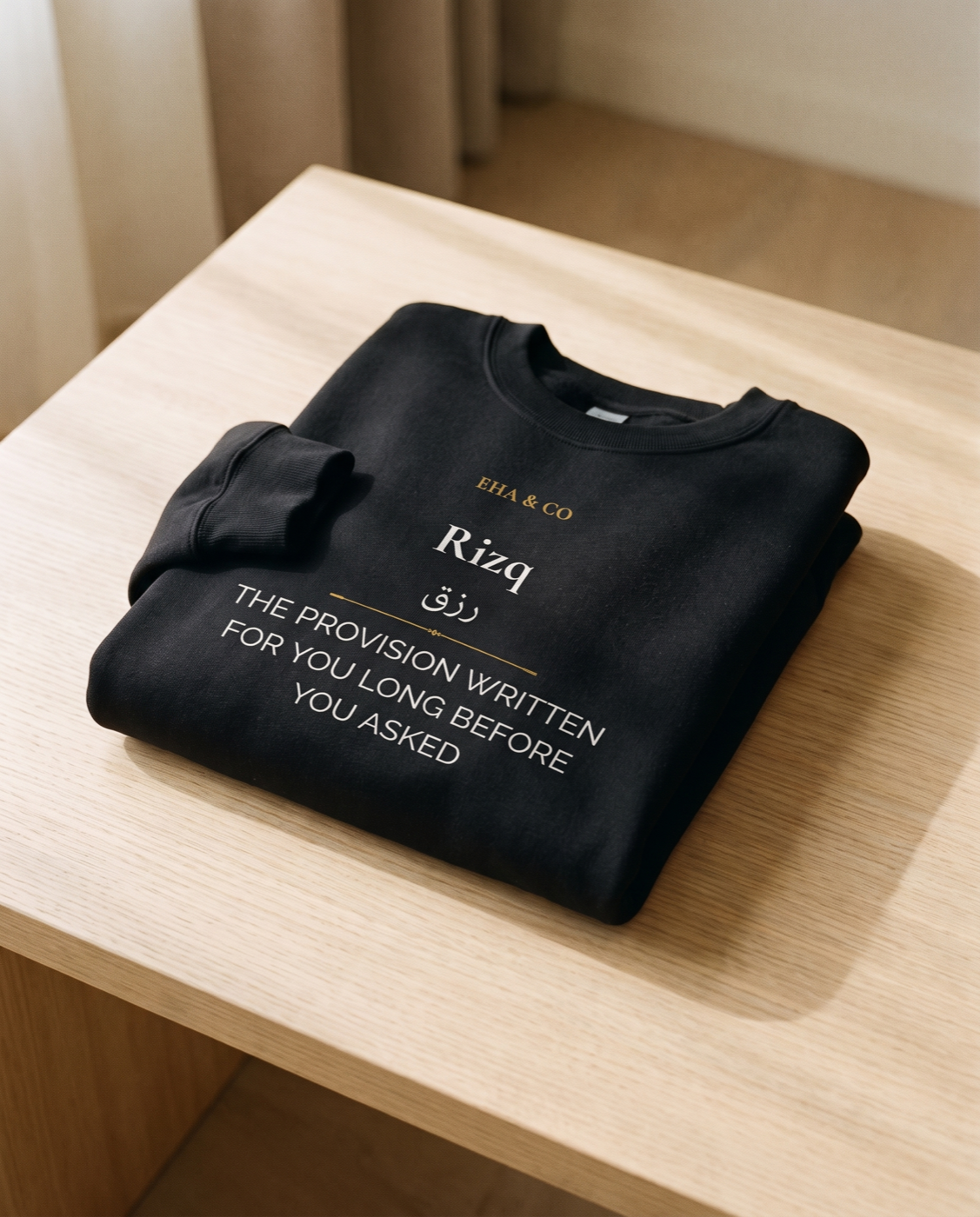 The Power of Rizq crewneck, the رزق print, on a warm plaster backdrop